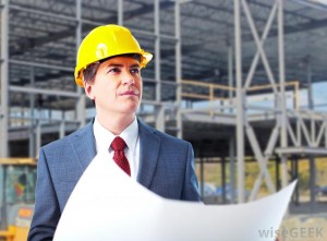 man-in-orange-hard-hat-and-business-suit-with-building-structure-in-the-background